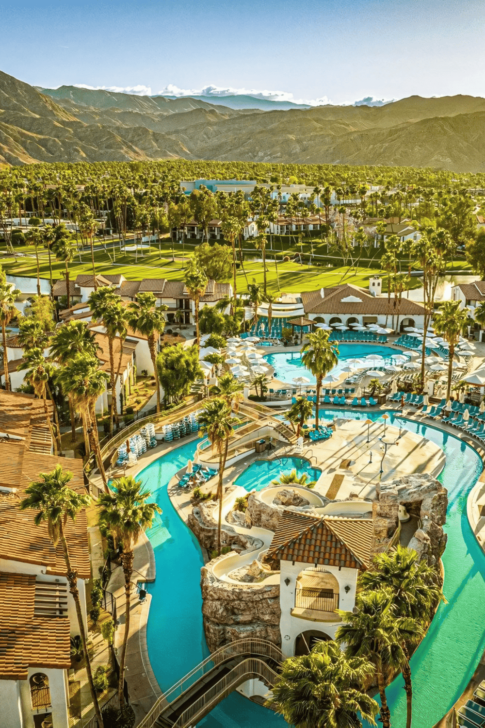 Outdoor resort swimming pool with waterfalls and palm trees at QuestForDirections.