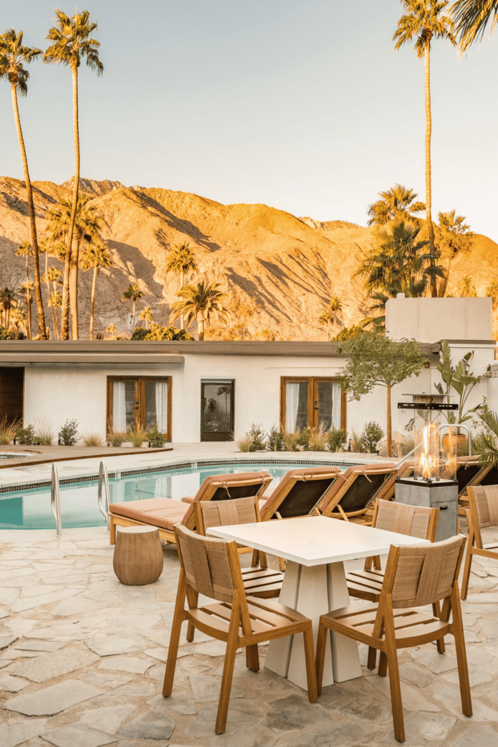 Modern desert getaway with pool, mountain views, and lush palm trees. Ideal for a relaxing vacation.