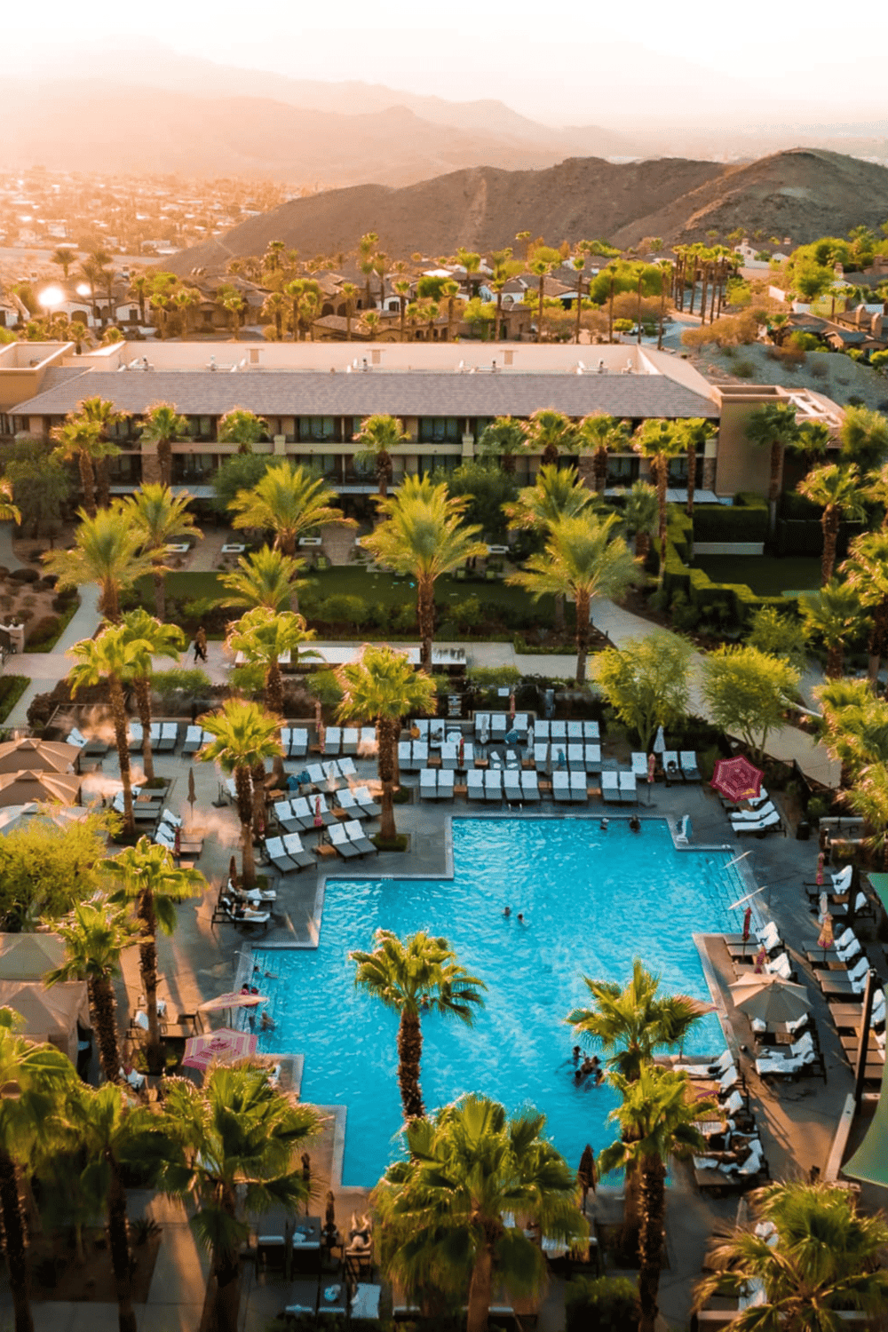 Elegant resort pool area with palm trees and mountain views for luxurious vacation experiences.