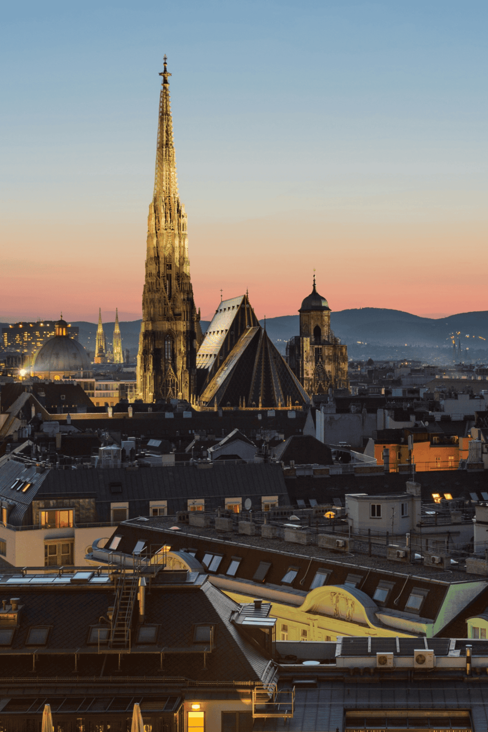 Iconic European city skyline featuring historic Gothic cathedral at sunset.