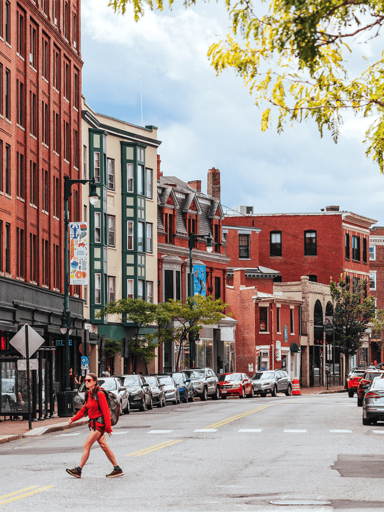 Colorful urban street with historic buildings and a pedestrian in red hiking gear, cityscape, and vibrant downtown, sightseeing.