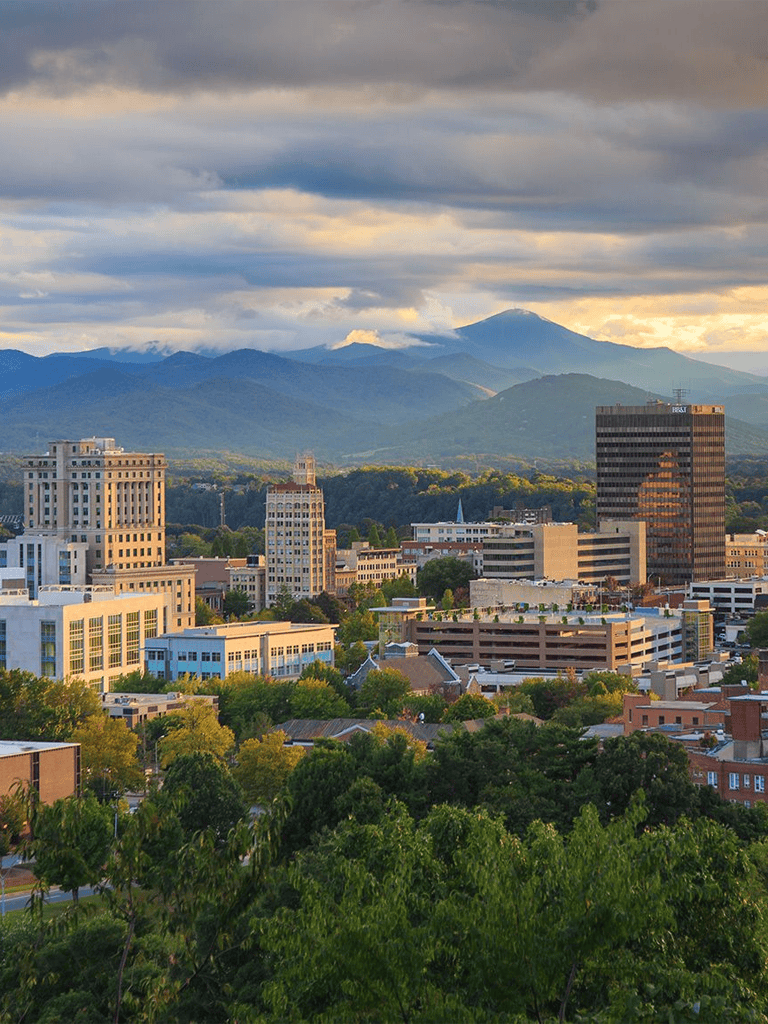 Vibrant city skyline with mountains in the background, highlighting urban development and scenic nature views.