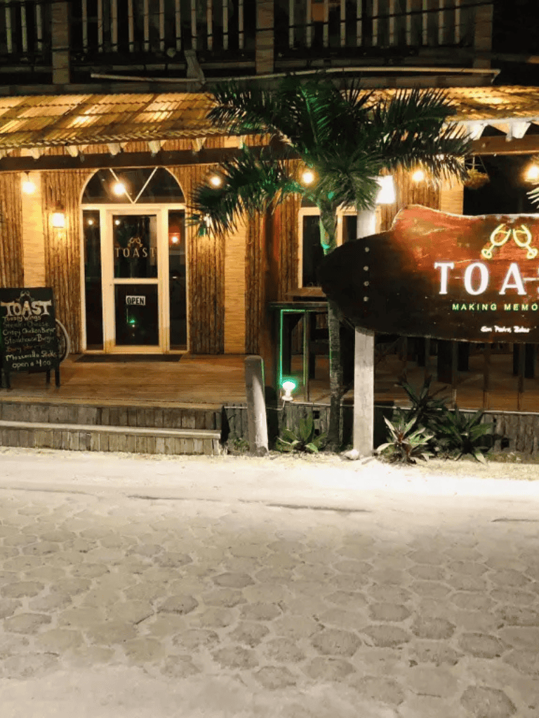 Outdoor restaurant at night with tropical decor and lighting, cozy atmosphere, popular for dining and memorable moments.