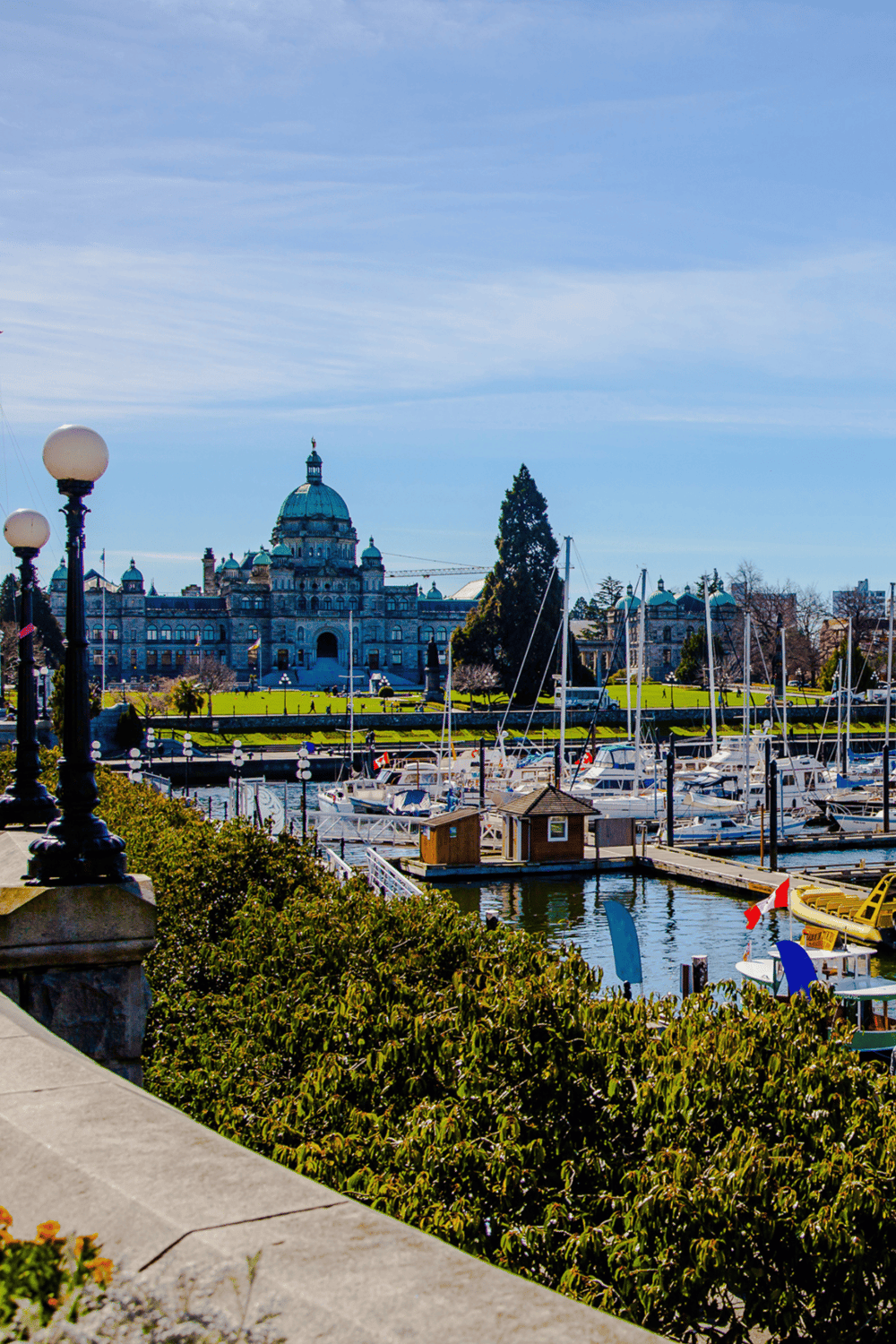 Historic harbor with marina and British Columbia Parliament Buildings in Victoria, BC.