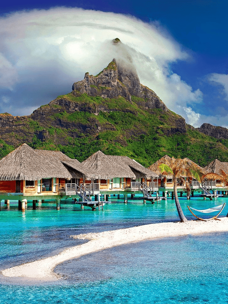 Overwater bungalows on turquoise lagoon at tropical island paradise in Bora Bora.