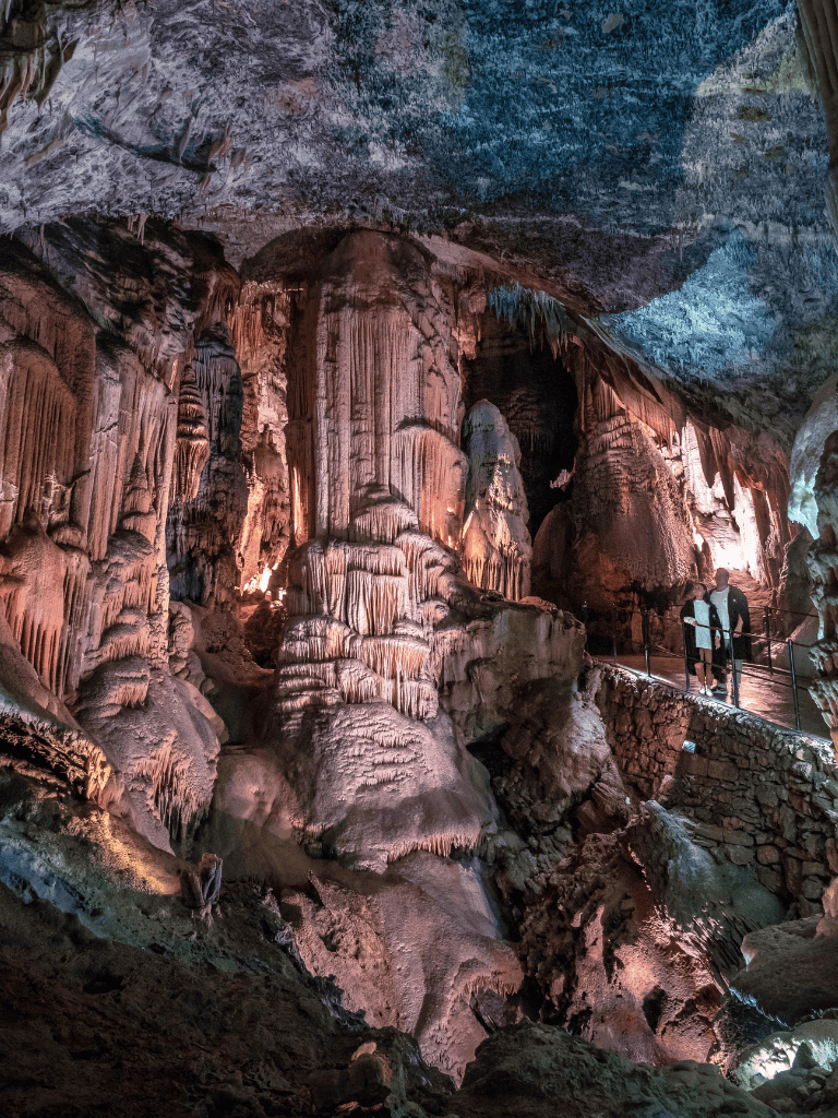 Stalactites and stalagmites inside a breathtaking cave formation, exploring underground natural wonders in a scenic cave tour.