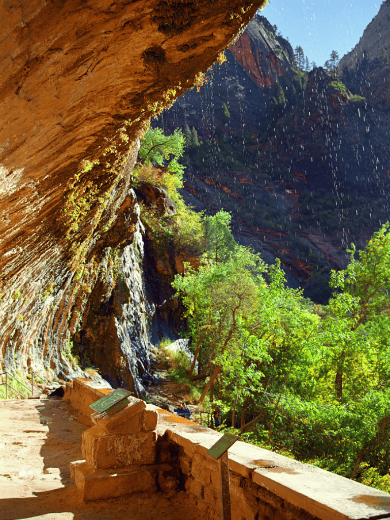 Vibrant lush green trees and towering red rock cliffs at Zion National Park, a stunning outdoor adventure destination.