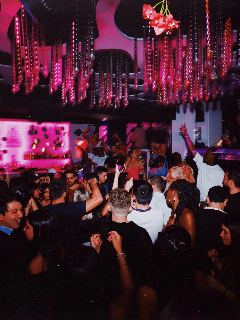 Vibrant nightclub scene with dancing and colorful lighting at QuestForDirections event venue.