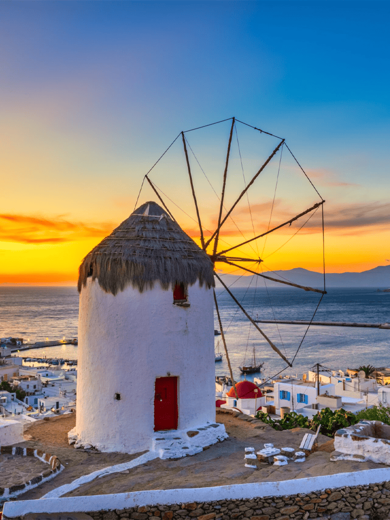 Ancient windmill in Santorini during sunset, showcasing Greek island charm and stunning views.