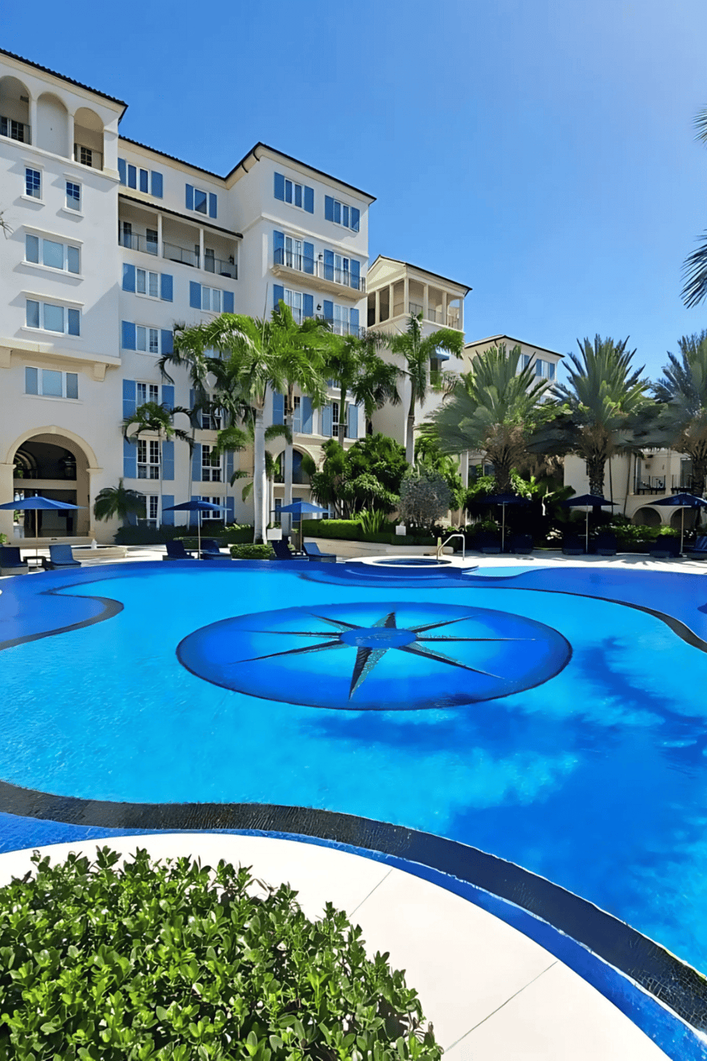 Luxury hotel pool with island and palm trees, bright sunny day, relaxing resort atmosphere, QuestForDirections.