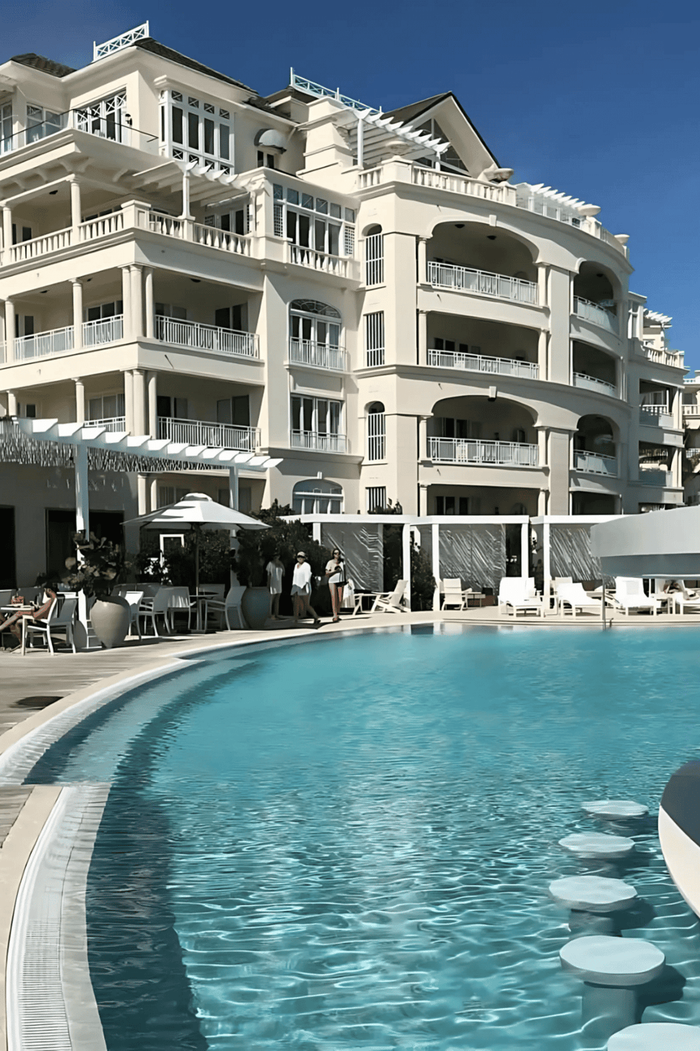 Luxurious oceanfront hotel with swimming pool and spacious balconies, perfect for a relaxing getaway.