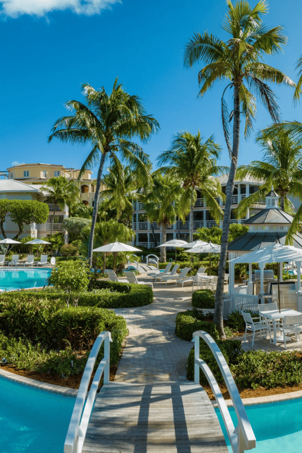 Relaxing hotel pool area with palm trees and tropical landscaping, perfect for vacation at Quest For Directions.