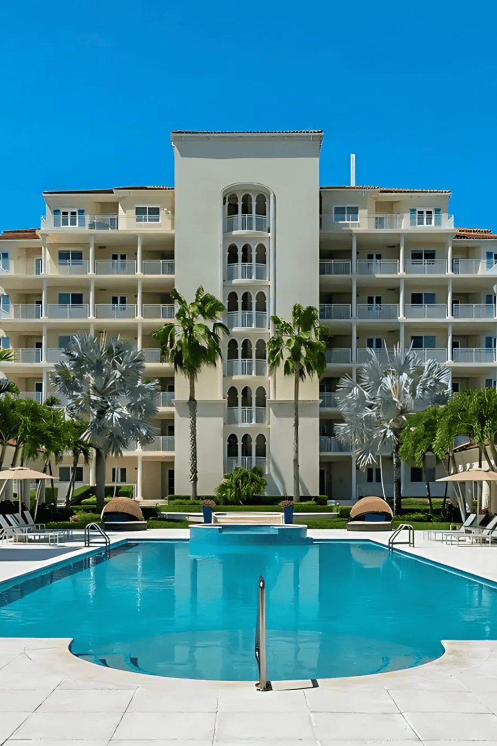 Poolside view of luxury condominium with palm trees at QuestForDirections.