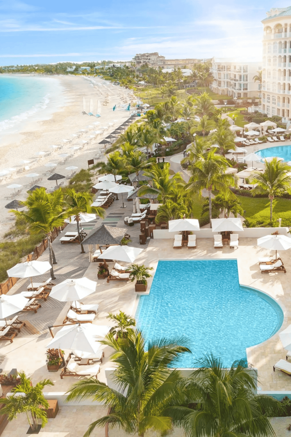 Luxurious beachfront resort with swimming pools and tropical gardens, perfect for relaxing vacations.