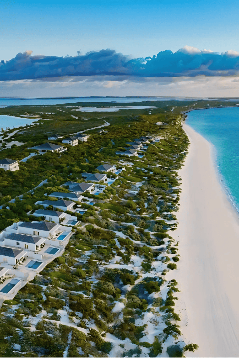 Seaside luxury villas with private pools along a pristine beach, perfect for a scenic getaway.