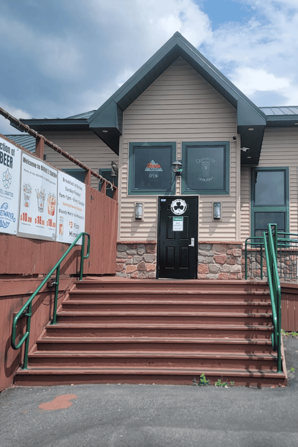 Stairway leading to a cozy pub or restaurant with a welcoming entrance and outdoor signage.