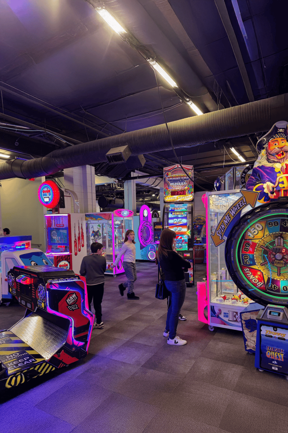Bright indoor arcade with colorful games and children enjoying entertainment activities.