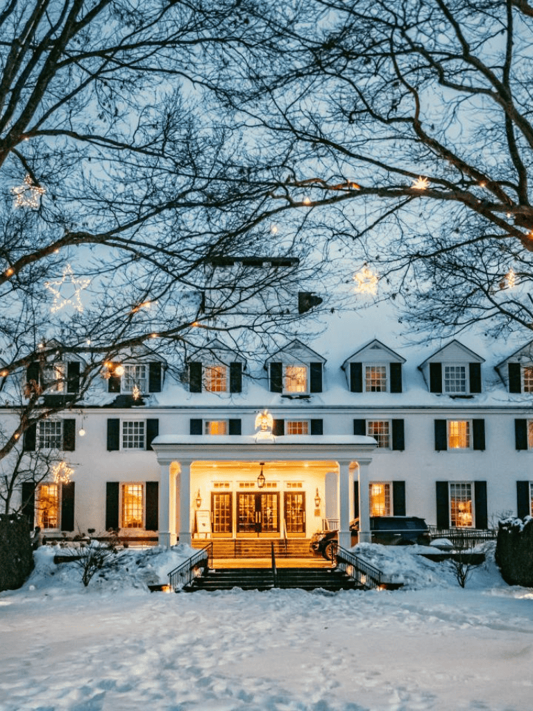Cozy winter mansion with snow and holiday lights, perfect for Christmas and holiday celebrations.