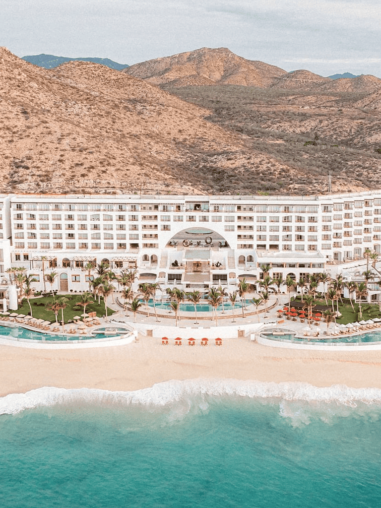Luxurious beachfront resort with ocean views and mountain backdrop, perfect for vacations and relaxing getaways.