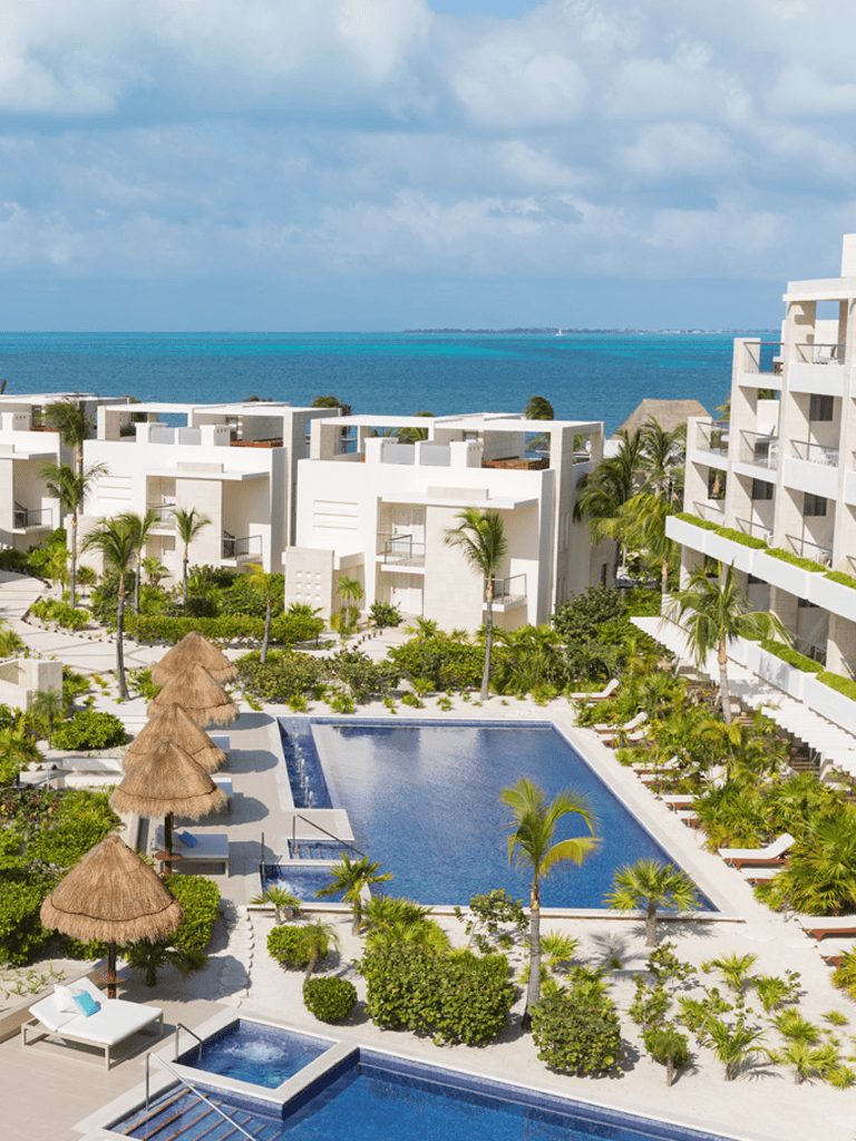 Luxury beachfront resort with infinity pools, tropical landscaping, and ocean views.