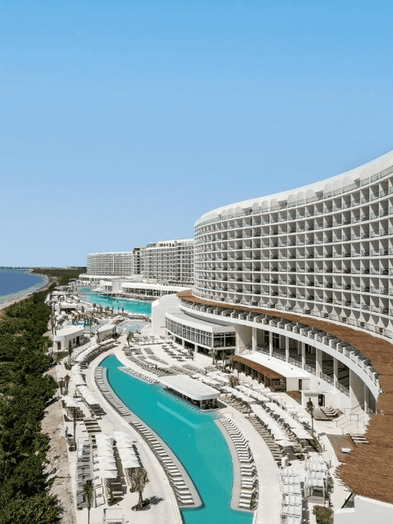 Luxury beachfront resort with pool, ocean views, and modern architecture for vacation relaxation.