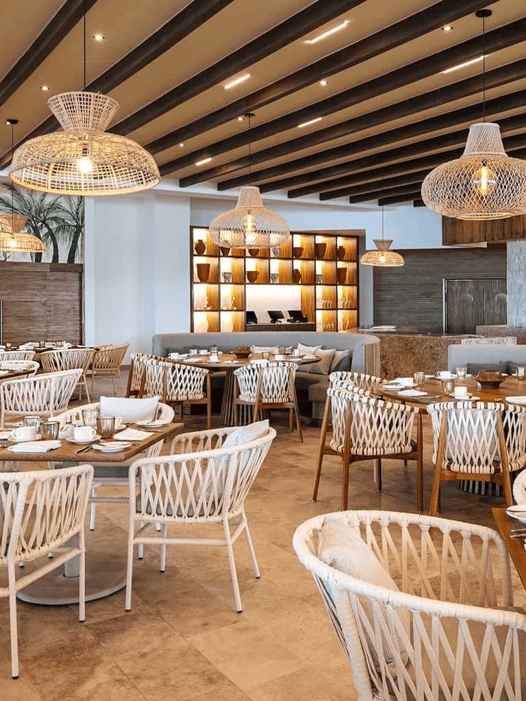 Elegant seaside restaurant interior with wicker lighting and wooden accents, perfect for dining and brunch.