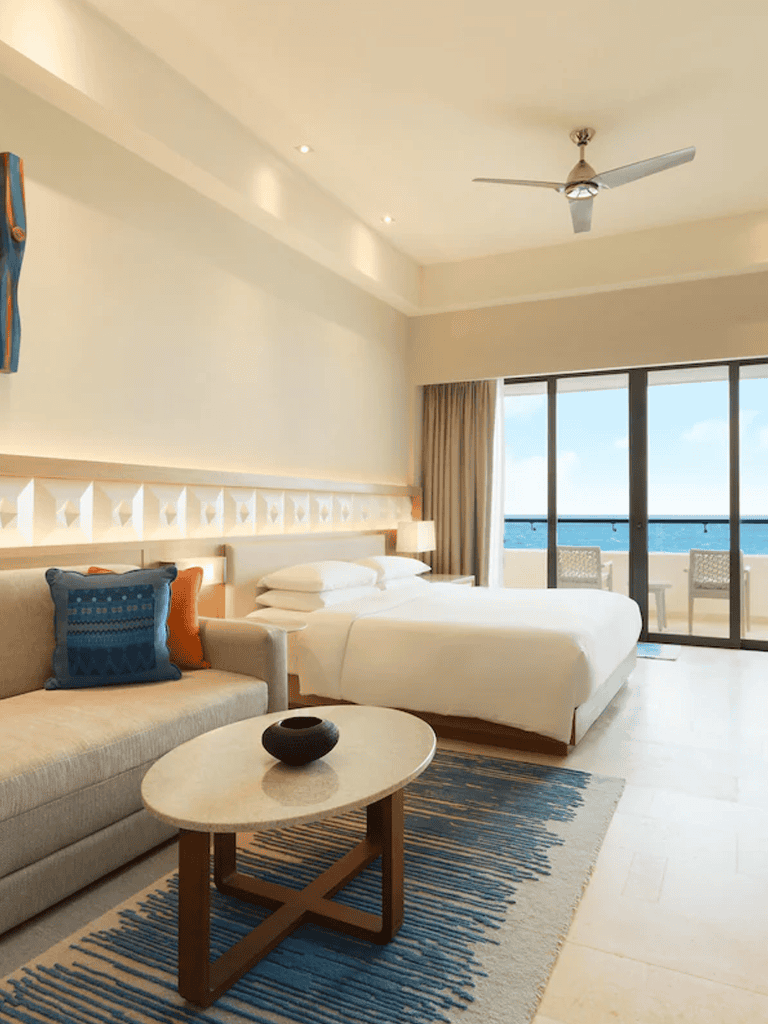 Luxurious beachside hotel room with ocean view and modern decor.