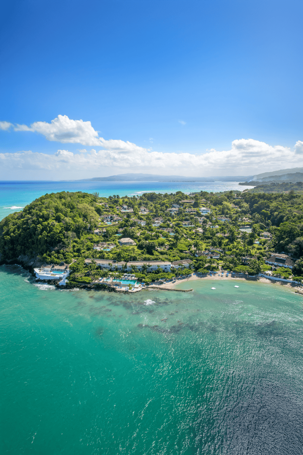 Coastal resort with ocean views, lush greenery, and sandy beaches for vacation relaxation.