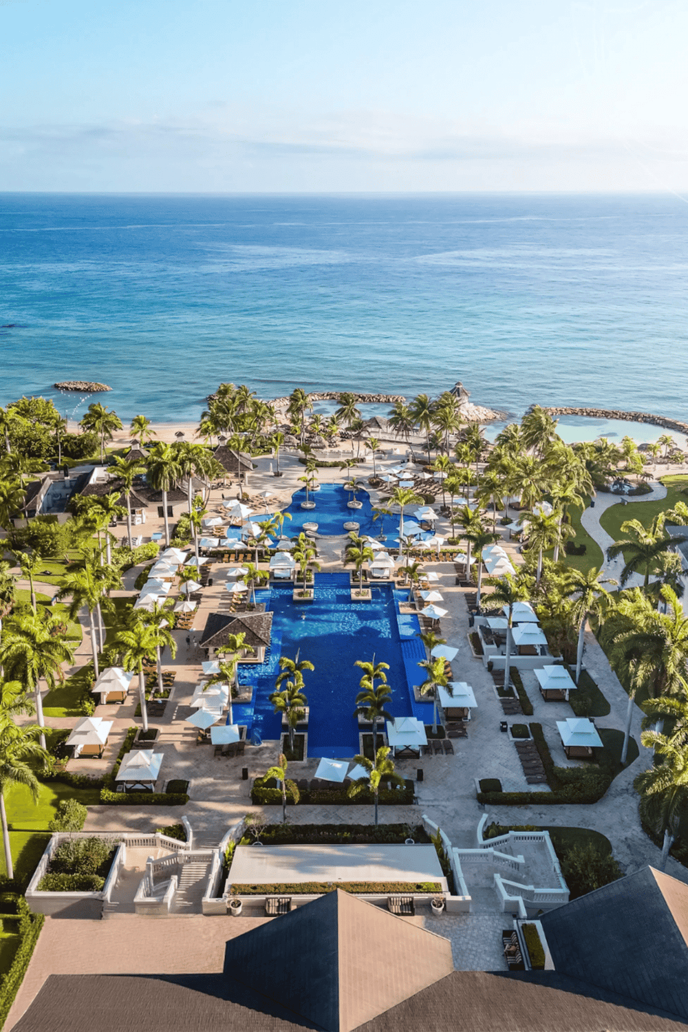 Luxury beachfront resort with swimming pools, palm trees, and ocean views for a perfect vacation.