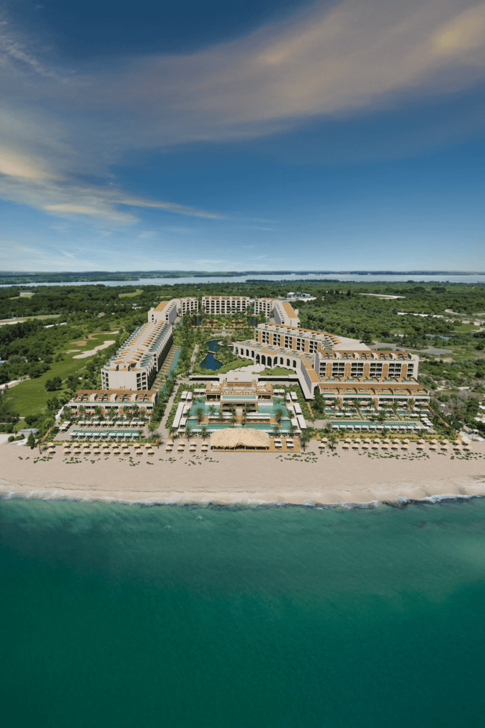 Luxurious beachfront resort with pools and lush greenery, perfect for a relaxing tropical vacation.