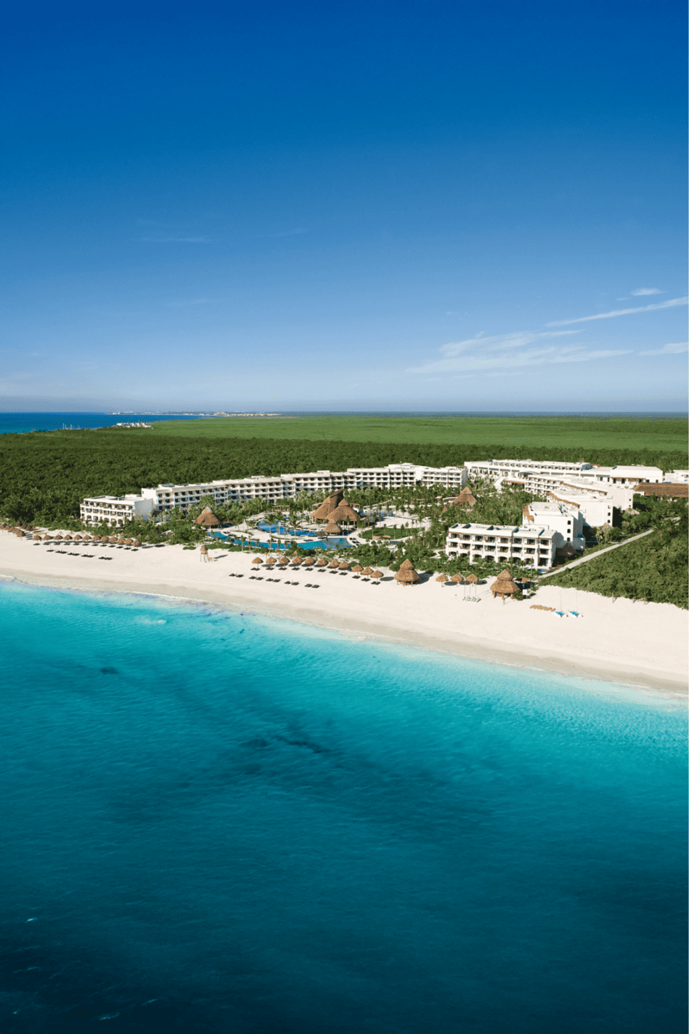 Beachfront resort with pools and lush greenery, perfect for a Caribbean vacation.