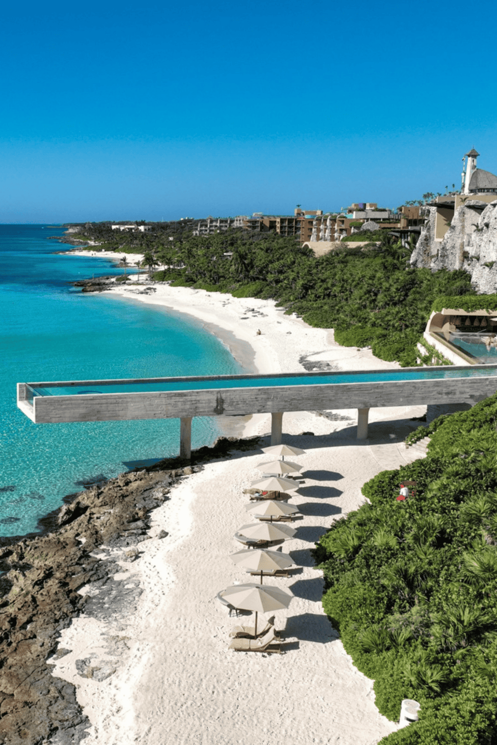 Luxurious beachside resort in Mexico with infinity pool, white sands, and stunning ocean views.