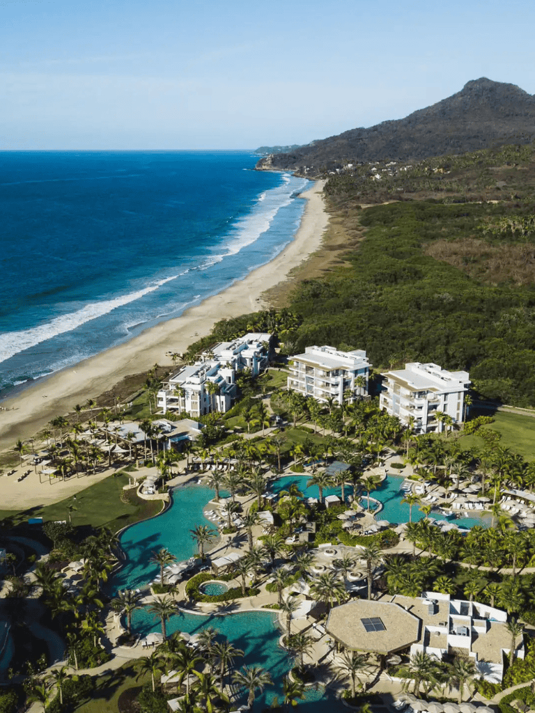 Luxury beachfront resort with pools and ocean views in a tropical coastal location.