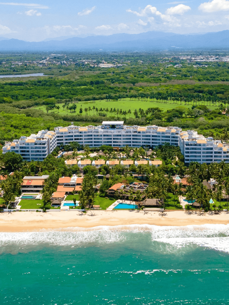 Luxury beachfront resort with pools and lush green gardens, ideal for travel and relaxation.