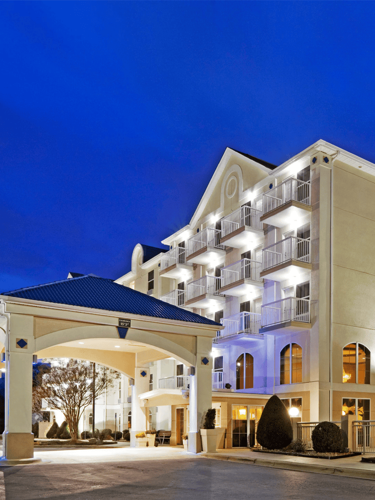 Luxury hotel exterior at night with illuminated balconies and elegant architecture.