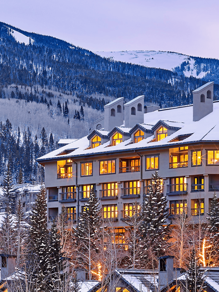 Snowy mountain resort with illuminated windows during winter in Colorado.