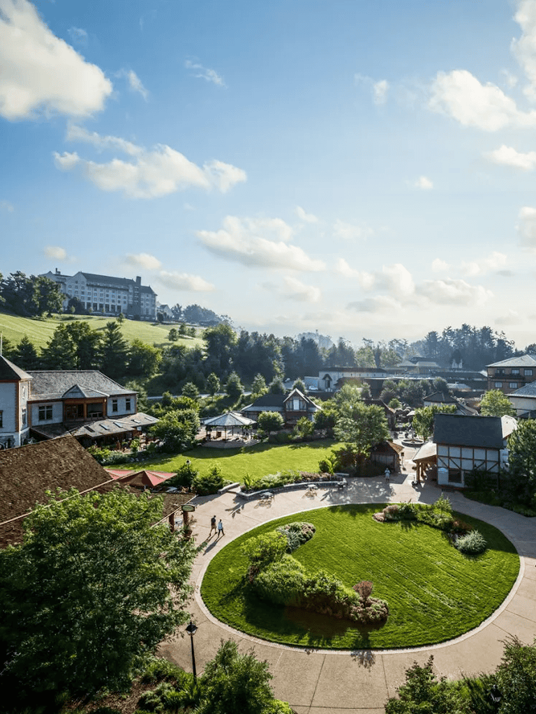 Lush valley with charming small town scene and scenic hillside view under blue sky.