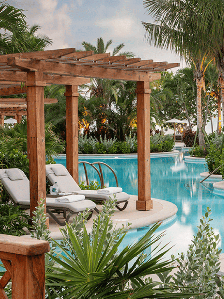 Relaxing poolside lounge with wooden pergola and tropical greenery at QuestForDirections.