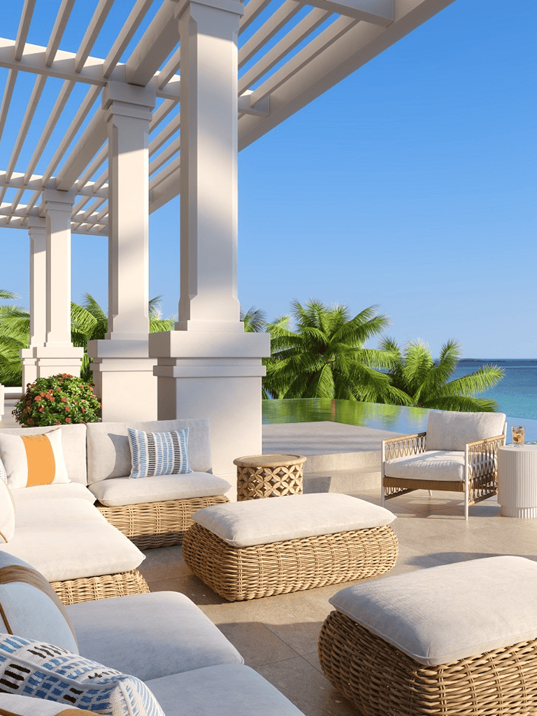 Luxury beachside outdoor seating area with tropical view and white pergola, perfect for relaxing.