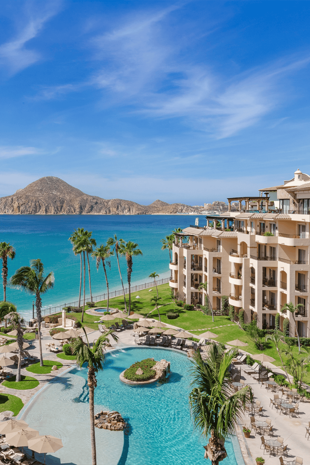 Luxurious beachfront resort with swimming pool, tropical palm trees, and stunning ocean views.