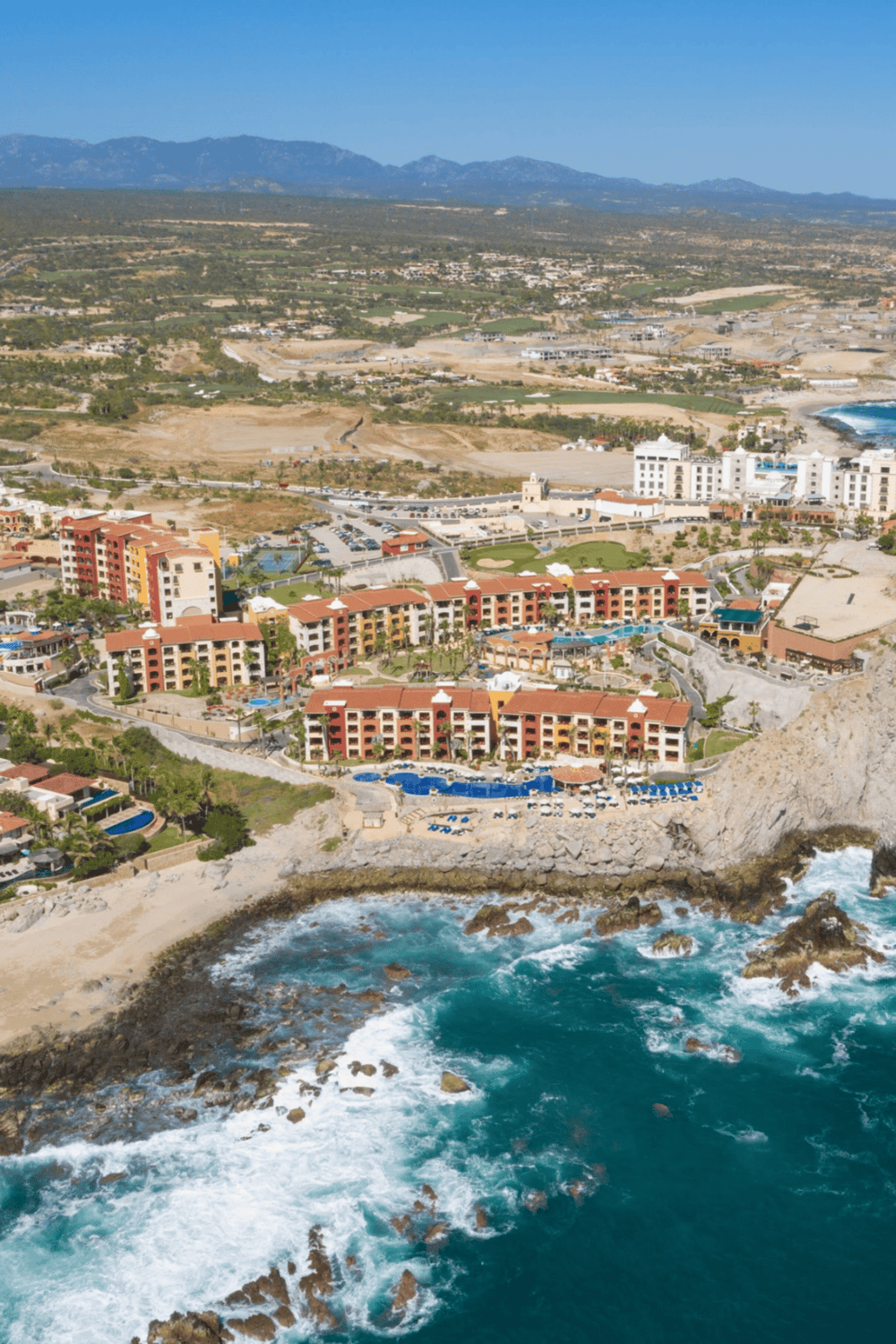 Luxury beachfront resort with ocean views and swimming pools in coastal scenery.
