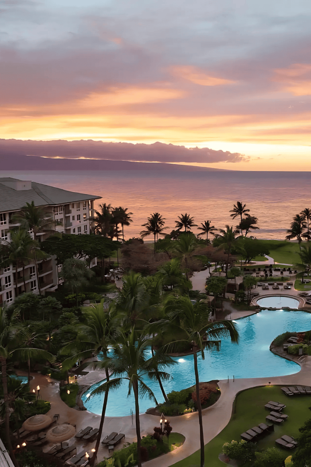 Beachfront resort during sunset with pool and palm trees, perfect for vacation & relaxation.