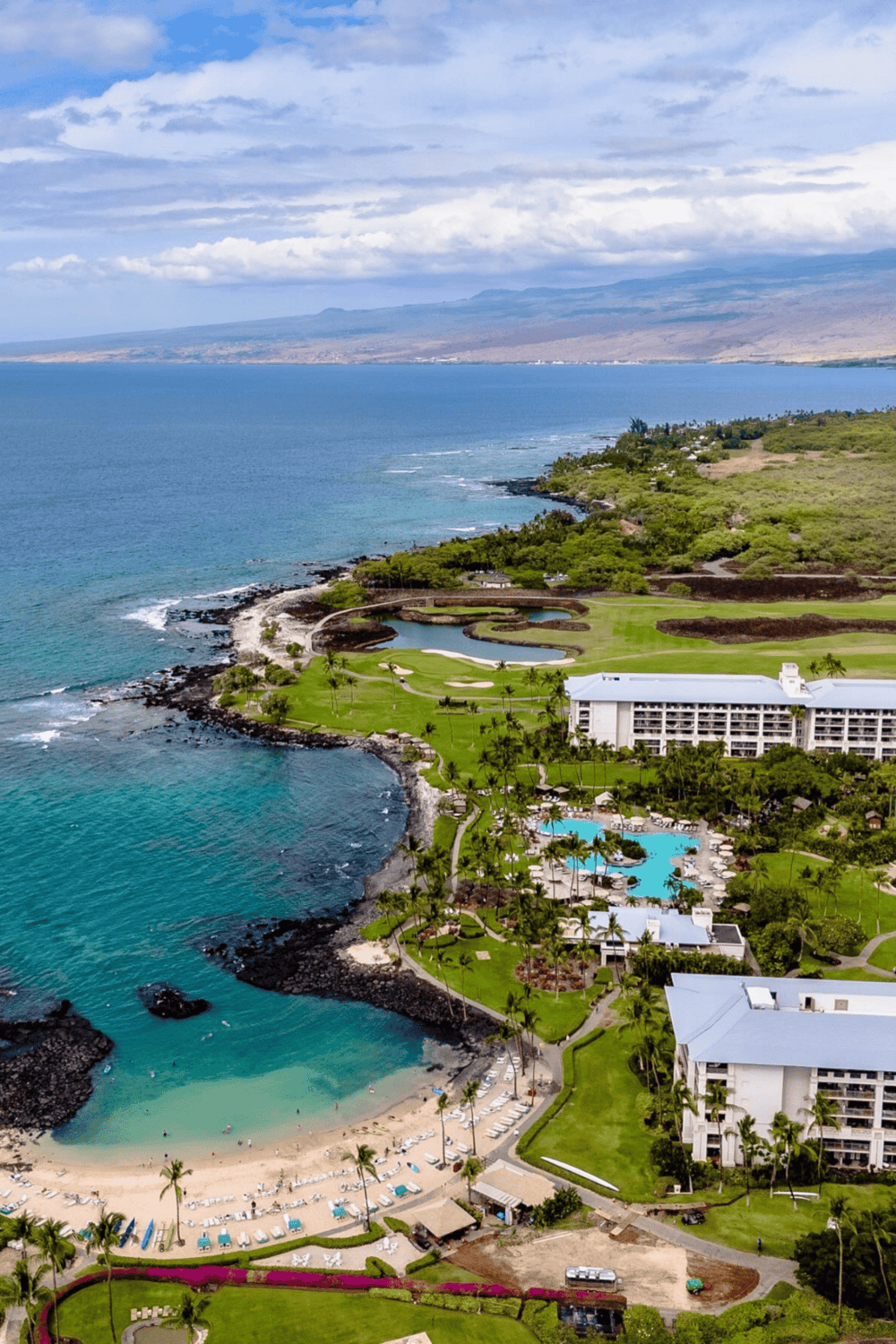 Overwater oceanfront resort with a private beach, golf course, swimming pools, and lush tropical landscape.