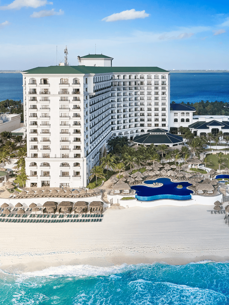 Luxurious beachfront hotel with swimming pools and ocean view for tropical vacation getaway.