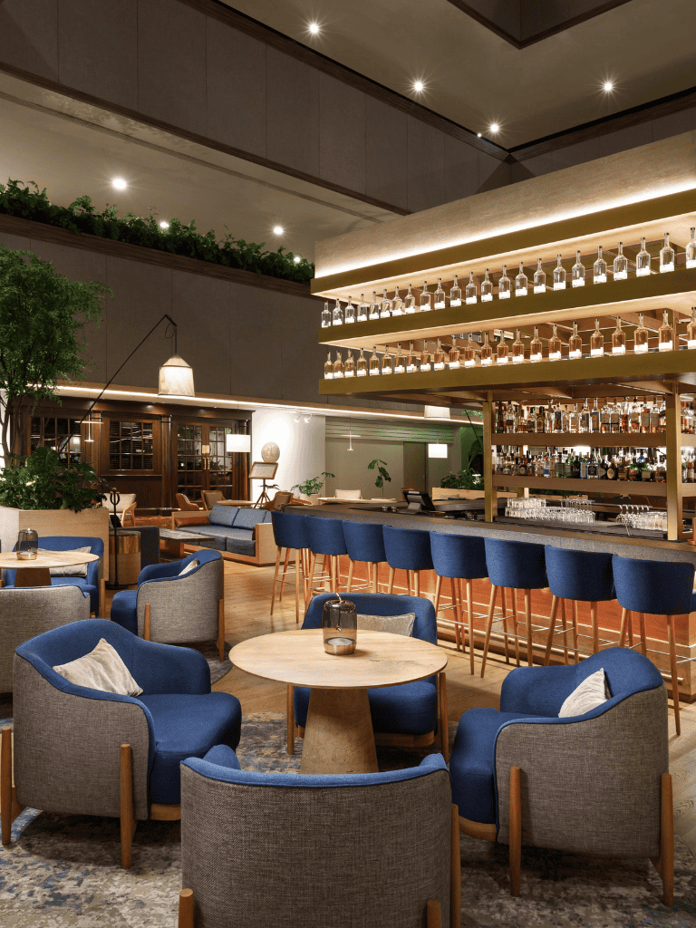 Modern hotel bar and lounge with stylish seating, contemporary decor, and extensive liquor display for guest relaxation.