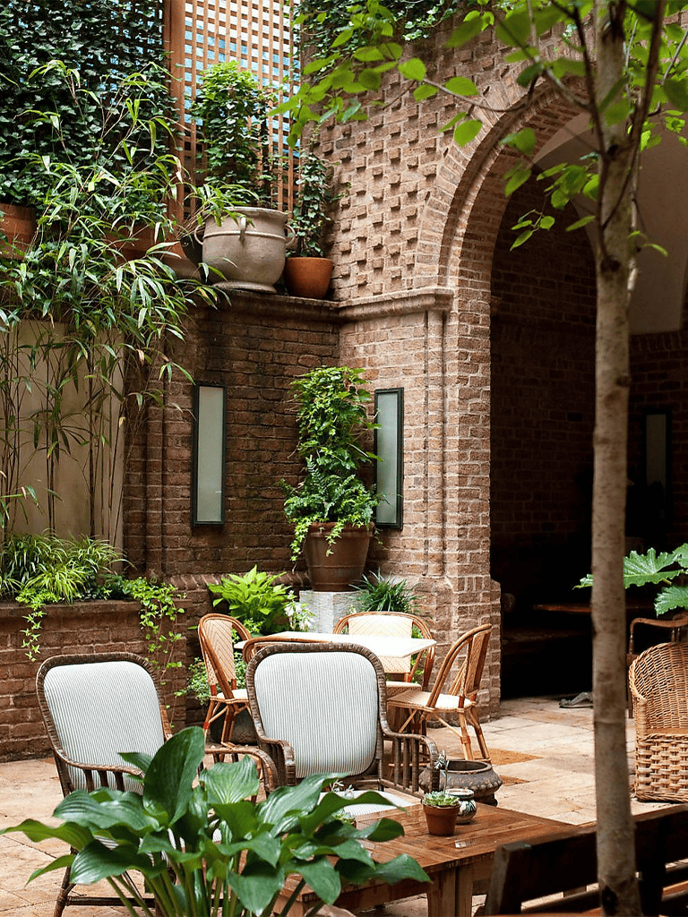 1. Indoor garden patio with brick arches and lush green plants for relaxing outdoor ambiance.