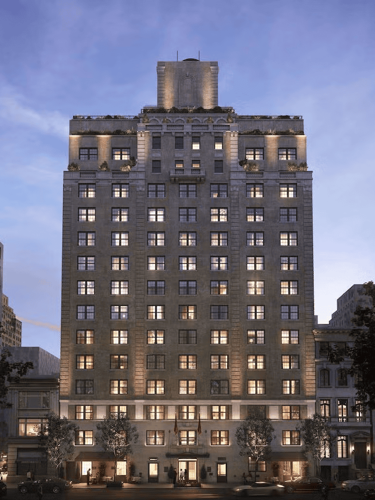 Elegant city hotel building illuminated at dusk with classic architecture and lit windows.