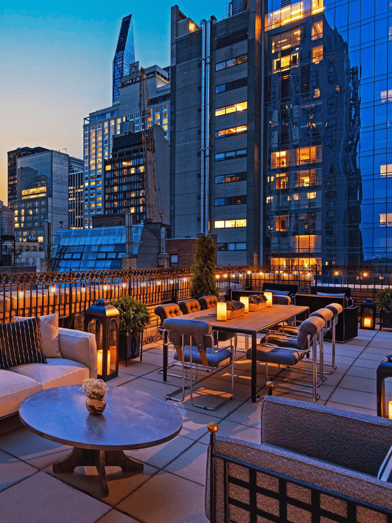 Modern city rooftop terrace with outdoor seating, city skyline views, and ambient lighting for urban relaxation and social gatherings.