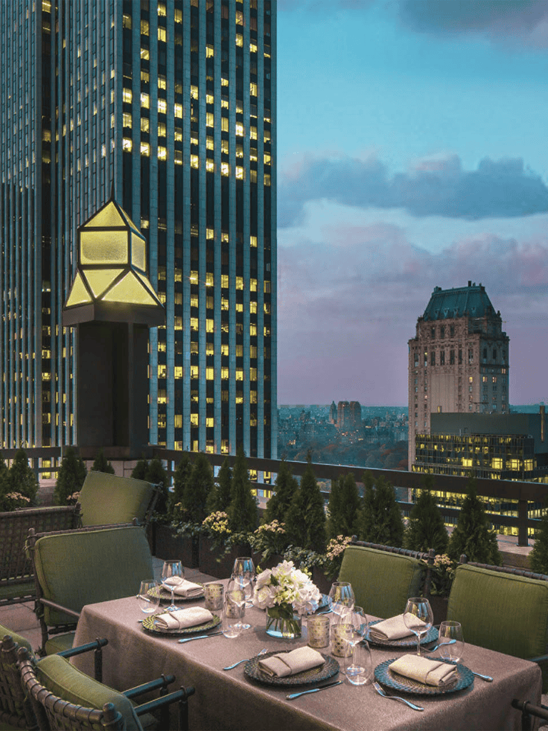 Modern city rooftop dining with city skyline view and elegant table settings.