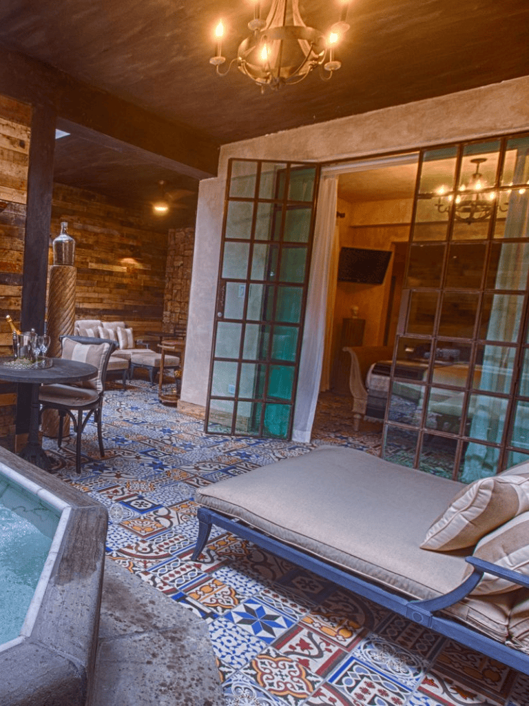 Elegant indoor lounging area with rustic decor, patterned tile flooring, and cozy furniture.